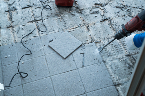 using a chisel to break and remove tile flooring