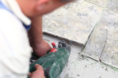 using a tool to remove the tiles